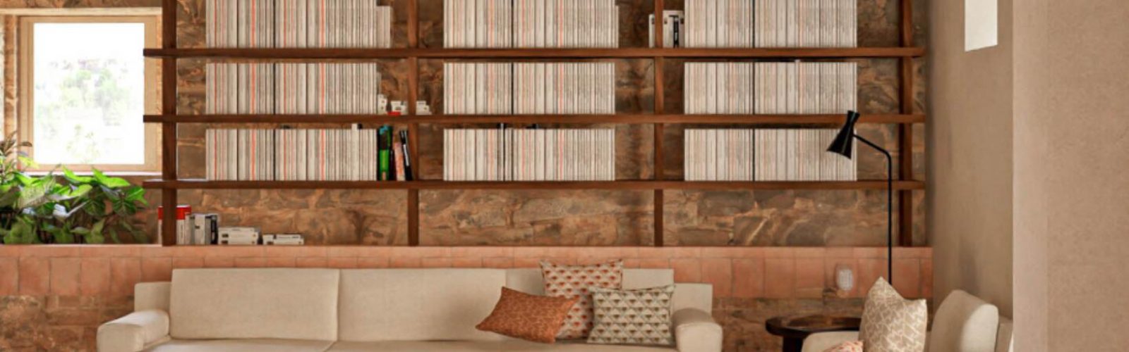 Interior of the farmhouse library on the 173-acre Agaporia estate, warm stone walls and receding shelves of books. The Beating Heart of The Conscious Club at the regenerative five-star sanctuary in Tuscany.